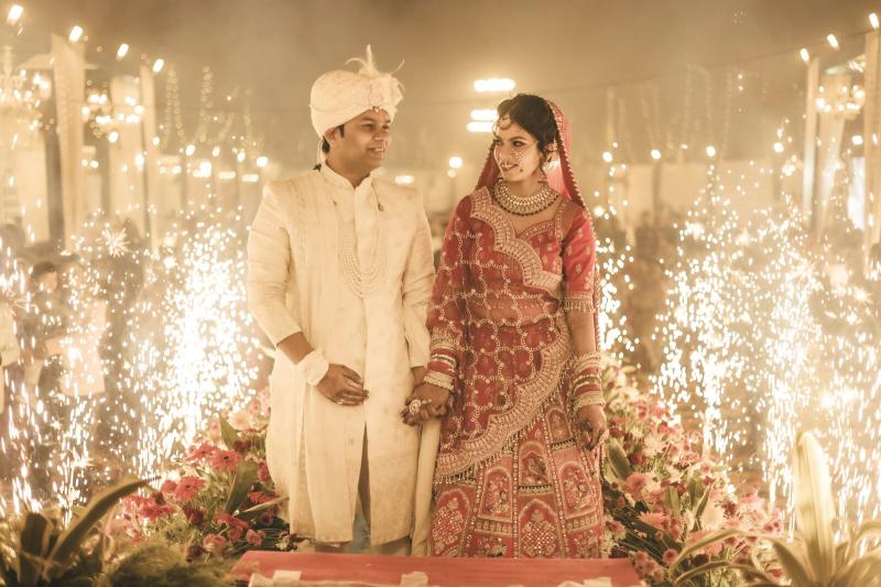 Couple standing between sparklers during the wedding entry, Prayagraj wedding photography