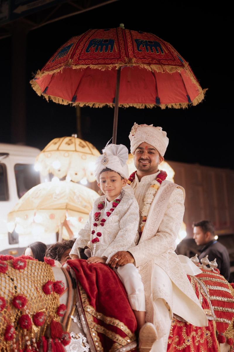 Groom on the ghodi under the ceremonial umbrella during the baraat, Prayagraj