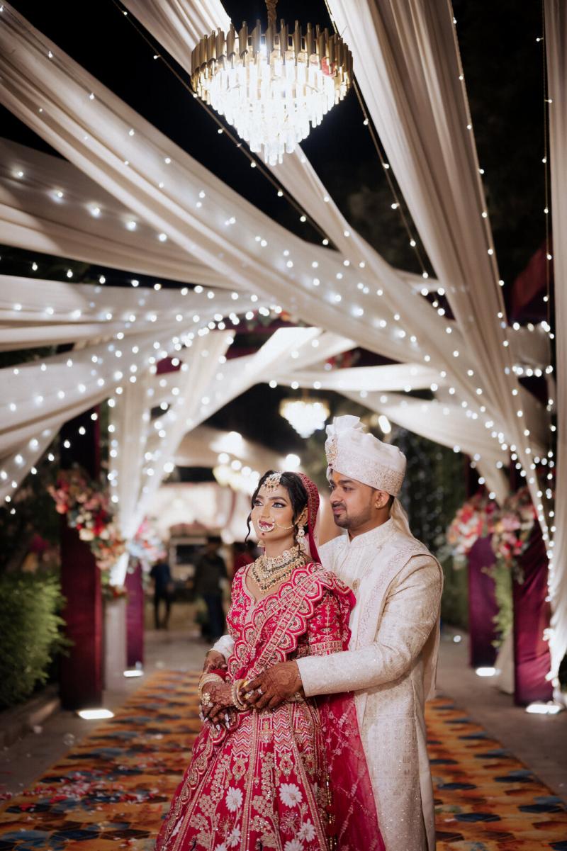 Bride and groom under a canopy of drapes and fairy lights, Prayagraj wedding