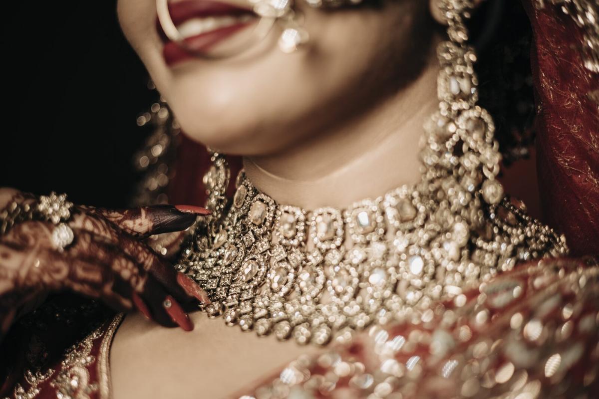 Detail shot of the bride's kundan necklace and mehendi hands, Prayagraj