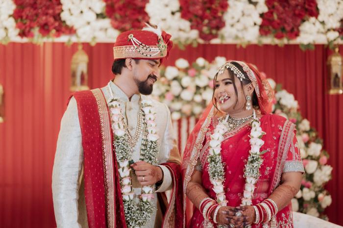 Bride and groom in their jaimala garlands on the floral stage, Prayagraj wedding
