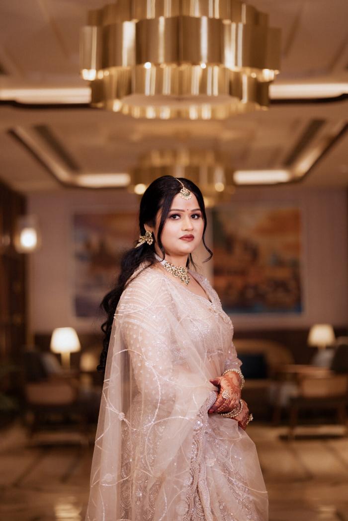 Bride in a pale pink lehenga under the chandeliers, Prayagraj wedding