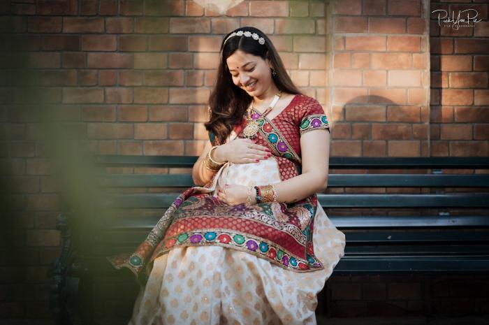 Mother-to-be seated on a park bench in a traditional outfit, maternity portrait by PickYouPic Prayagraj