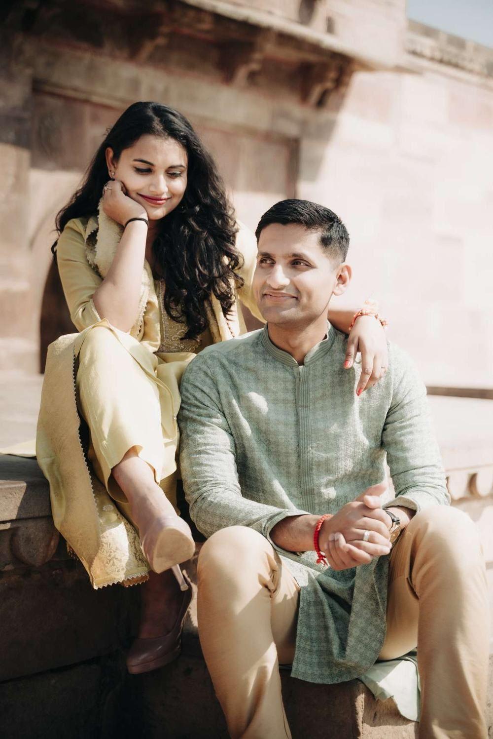 Couple sitting together on the steps of a sandstone monument during a pre-wedding shoot