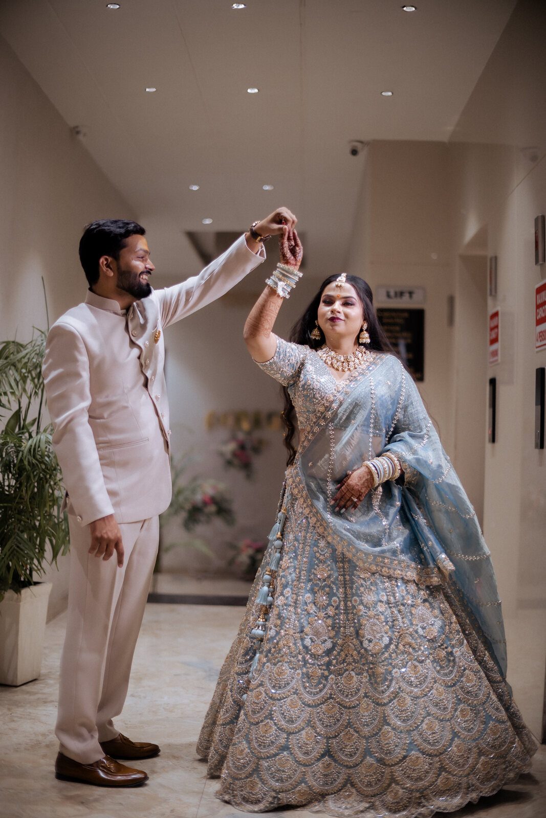 Groom twirling his bride in the hotel corridor, Prayagraj wedding photography