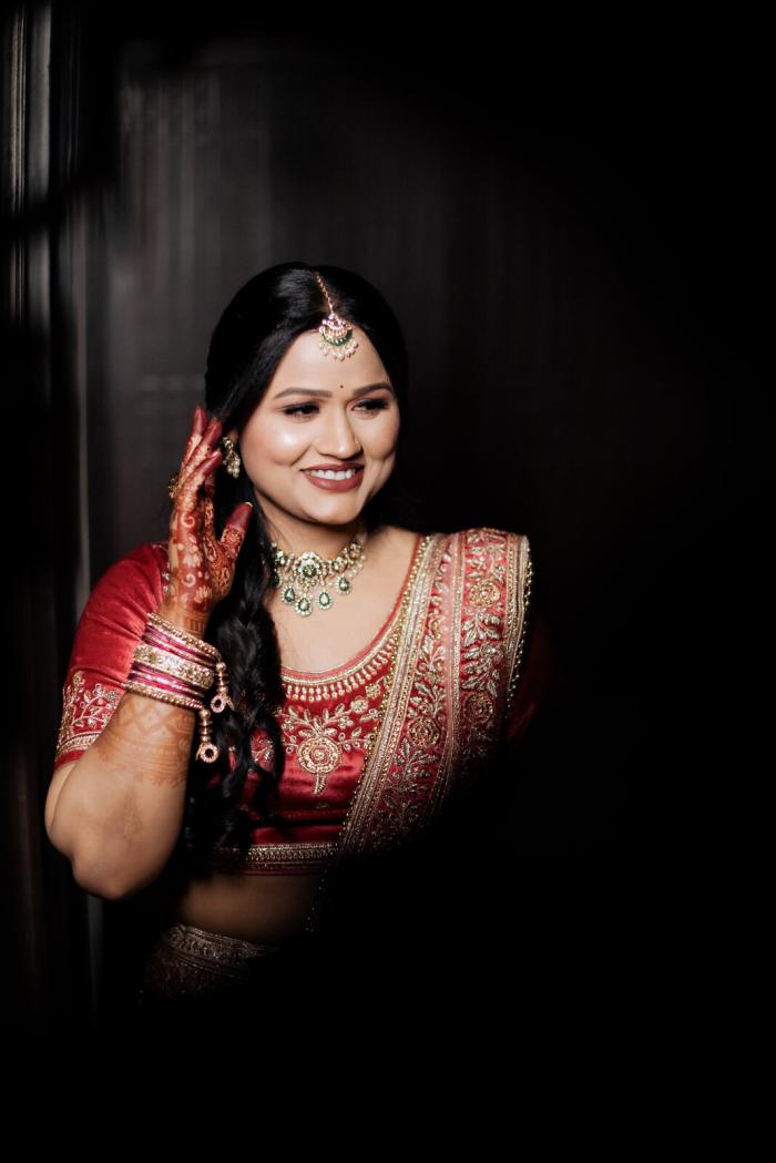 Bride in red against a dark backdrop, Prayagraj wedding portrait