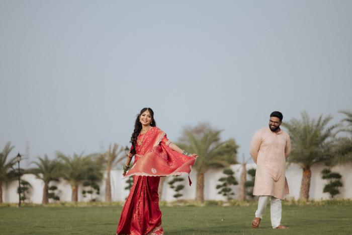 Bride twirling her saree on the lawn as the groom watches, Prayagraj