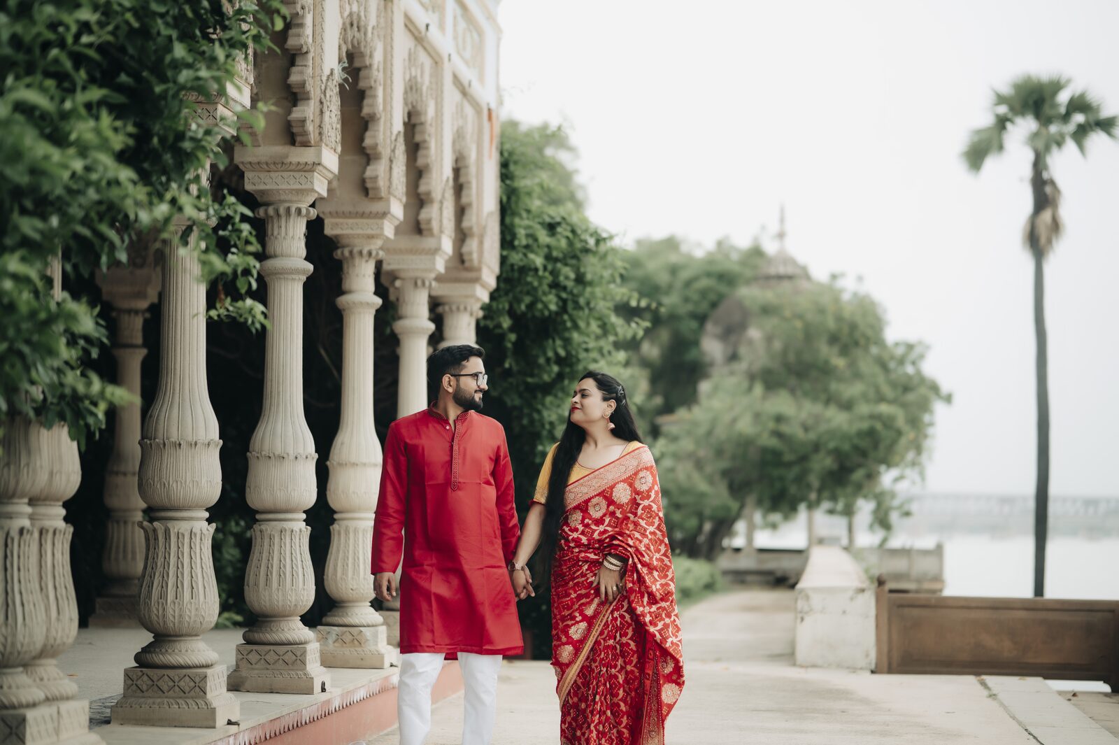 Couple by riverside pillars at sunset, pre-wedding shoot location in Prayagraj