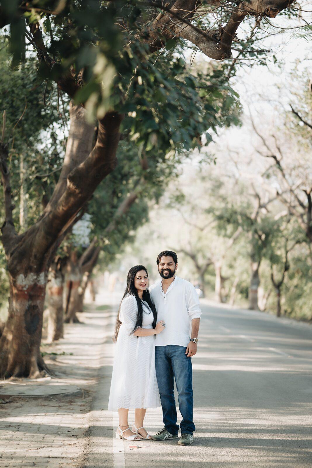 Couple standing on a quiet tree-lined road, pre-wedding shoot location
