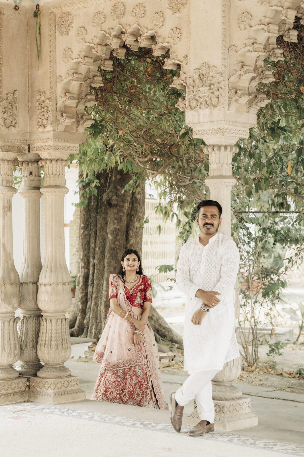 Couple framed by heritage arches and greenery, pre-wedding location