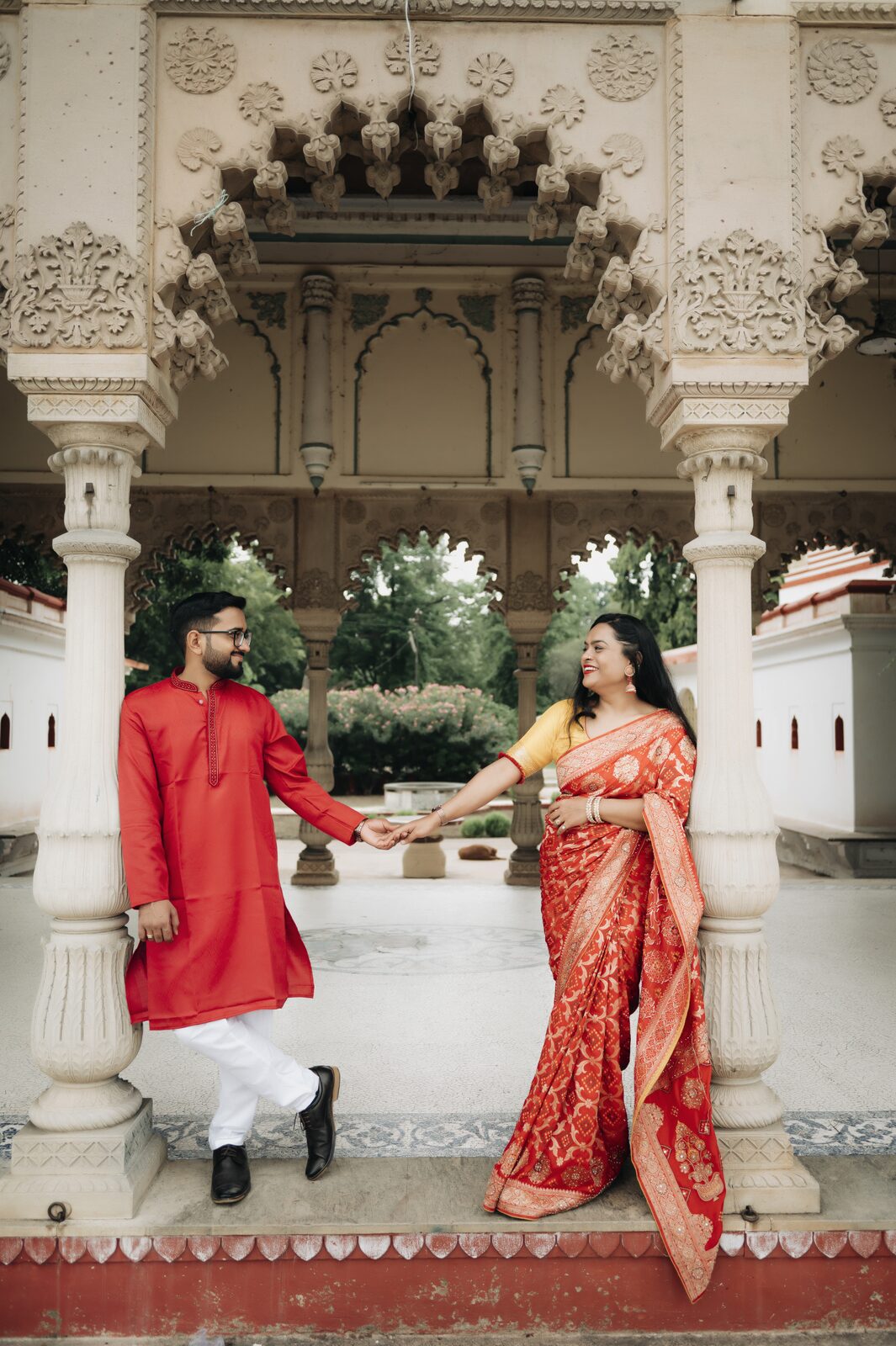 Couple in traditional red at a temple courtyard, pre-wedding shoot location