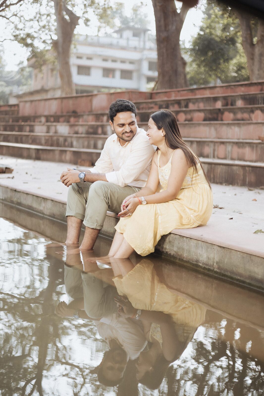 Sitting on the ghat steps with feet in the water, Chitrakoot pre-wedding shoot