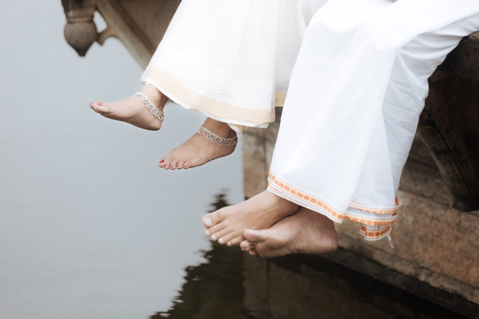 Anklets and bare feet above the water, detail shot at Ganesh Bagh Chitrakoot