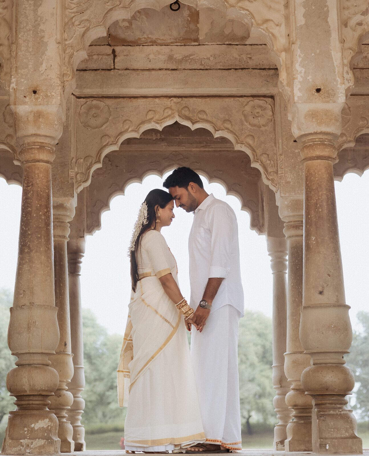 Couple framed in a scalloped arch overlooking the lake at Ganesh Bagh, Chitrakoot