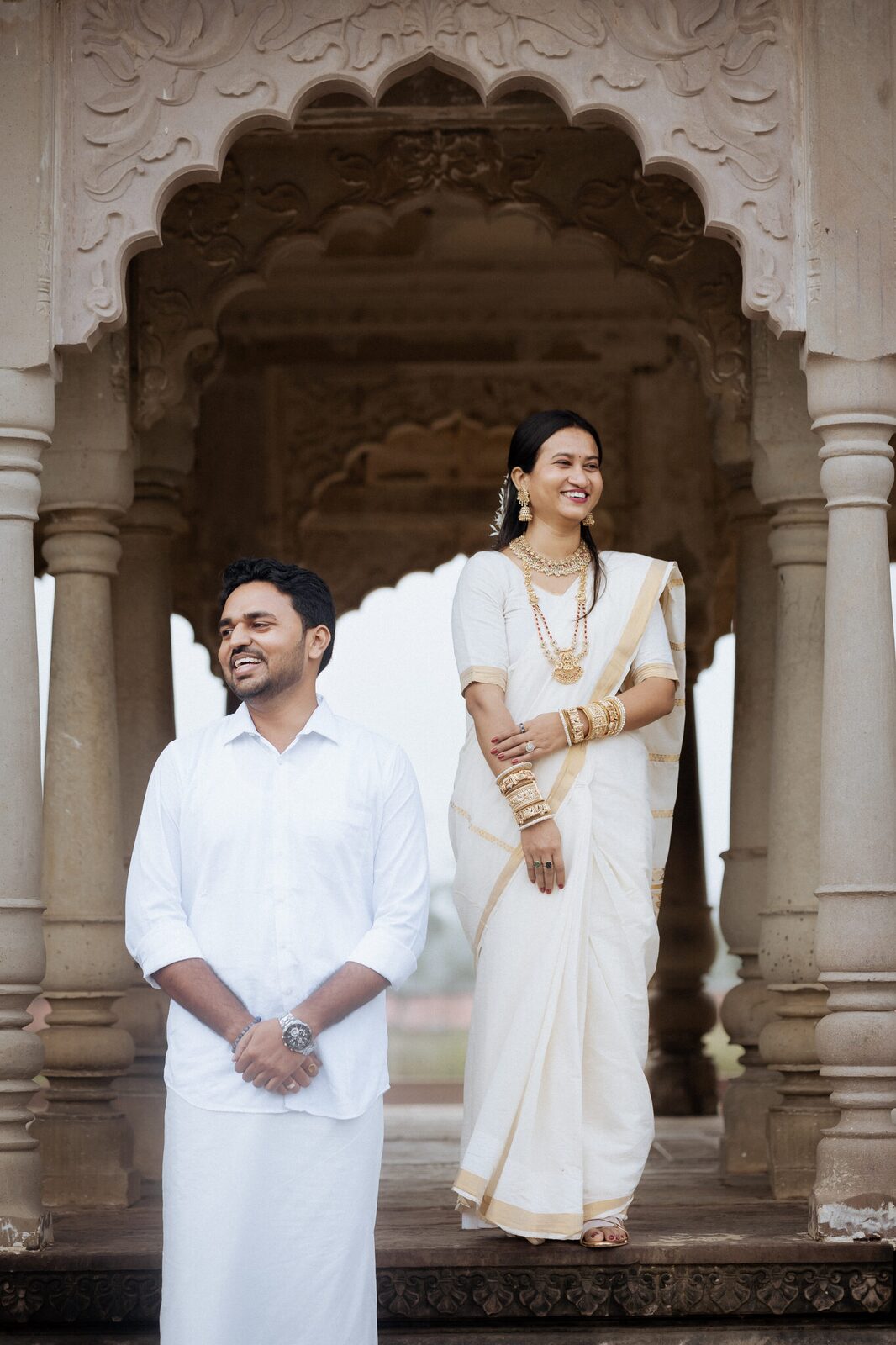Couple in Kerala kasavu attire in the carved colonnade at Ganesh Bagh, Chitrakoot