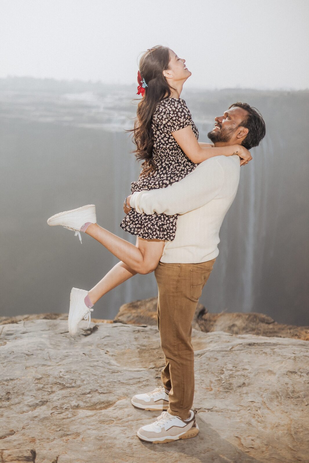 Groom lifting his bride-to-be above Keoti Waterfall