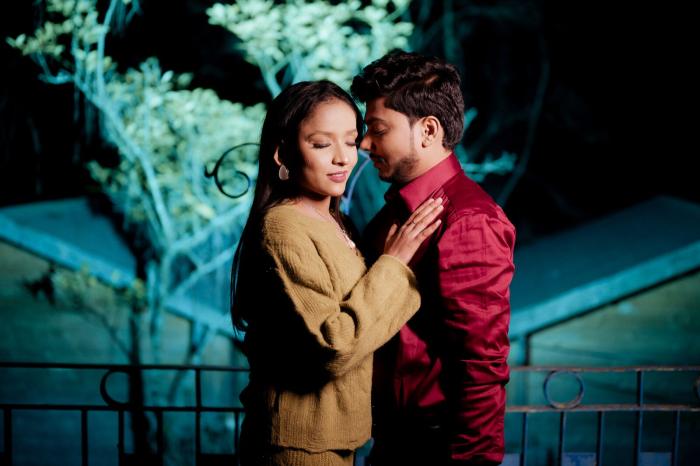 Pre-wedding photo lit against teal-lit pines at night in Mukteshwar