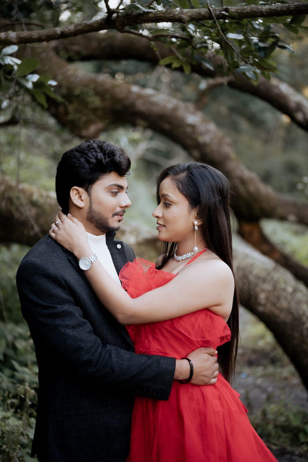 Couple embracing under a bent oak tree on their Mukteshwar pre-wedding shoot