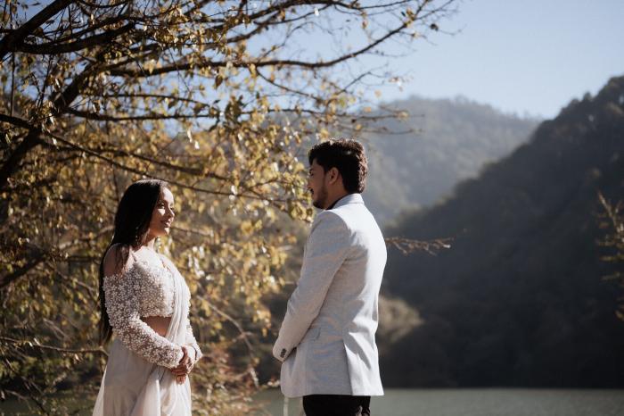 Autumn pre-wedding photo under golden trees with the Nainital hills behind