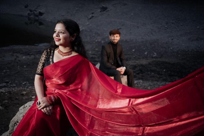 Bride-to-be in a red saree on a rock by the lake shore, Nainital pre-wedding shoot