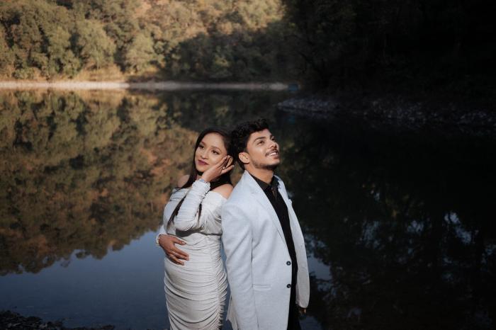 Still lake reflecting the hills behind a pre-wedding portrait in Nainital