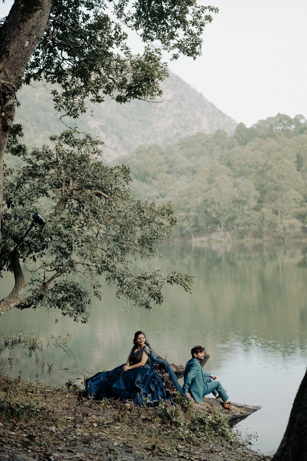 Quiet lake with mirror reflections framing a pre-wedding portrait in Nainital