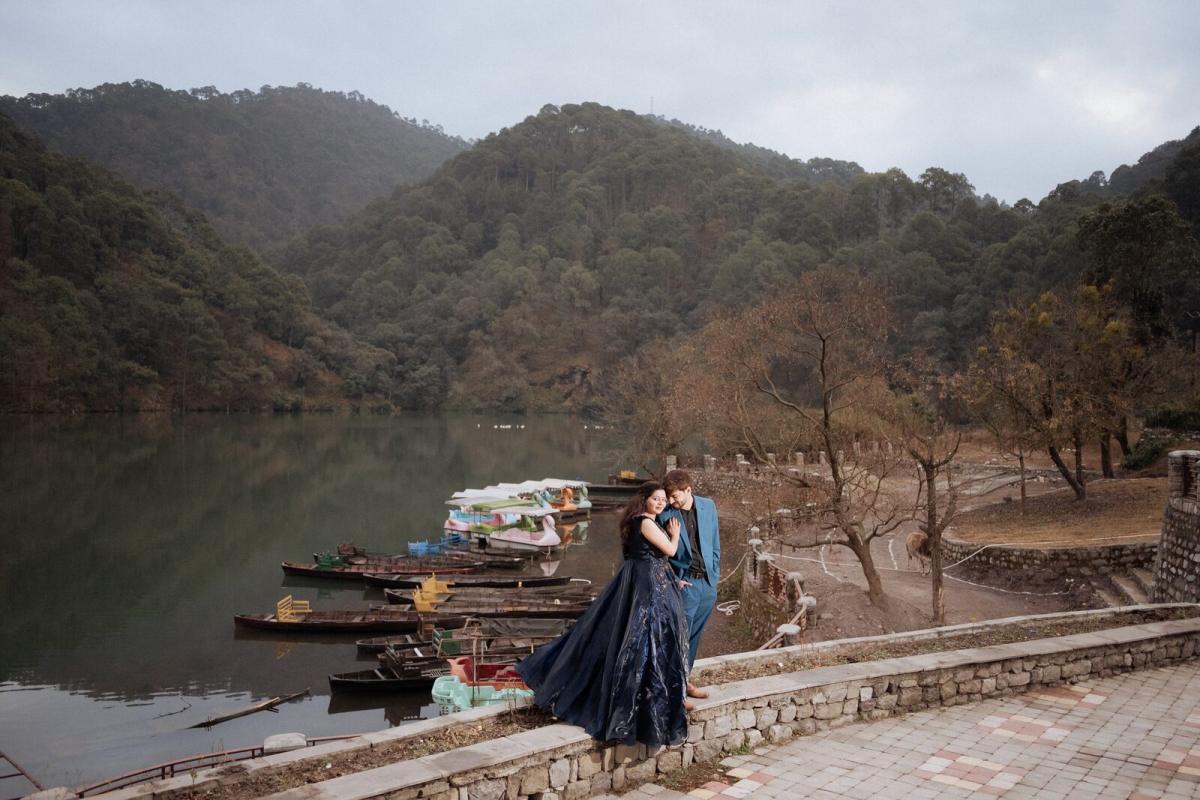 Sattal Lake pre-wedding shoot — couple by the water with boats and misty hills behind
