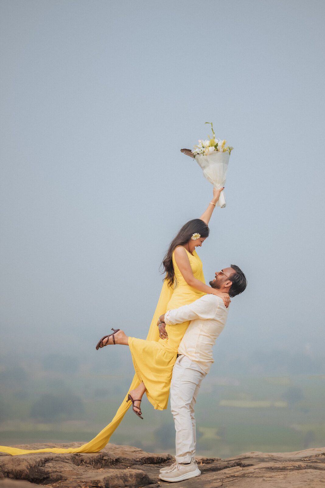 Groom lifting his bride-to-be with a bouquet on Pabhosa hill