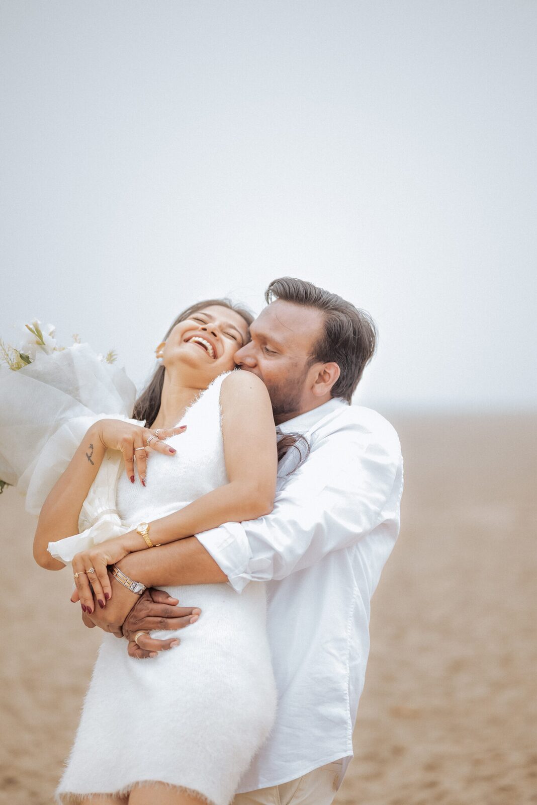 Bride-to-be laughing in her groom arms on the Yamuna sands near Pabhosa