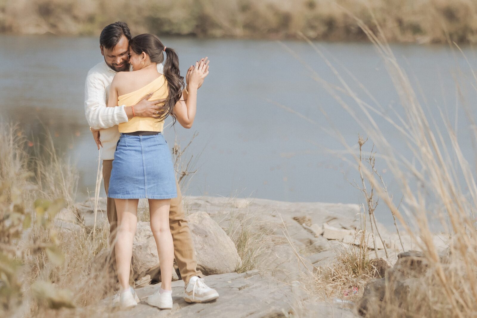 Couple embracing in tall grass by the Yamuna near Pabhosa