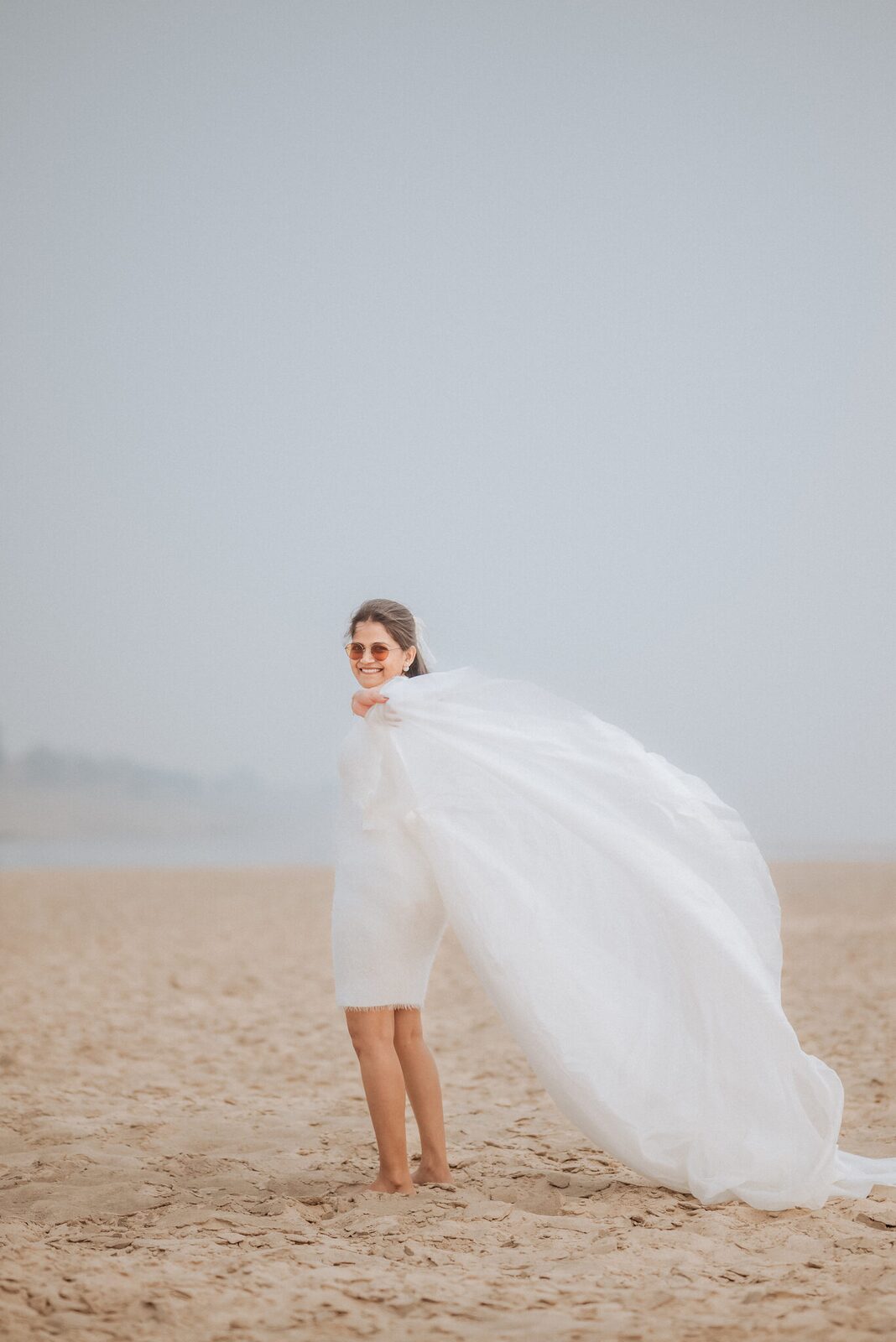 Bride-to-be with her veil catching the wind on the Yamuna sands
