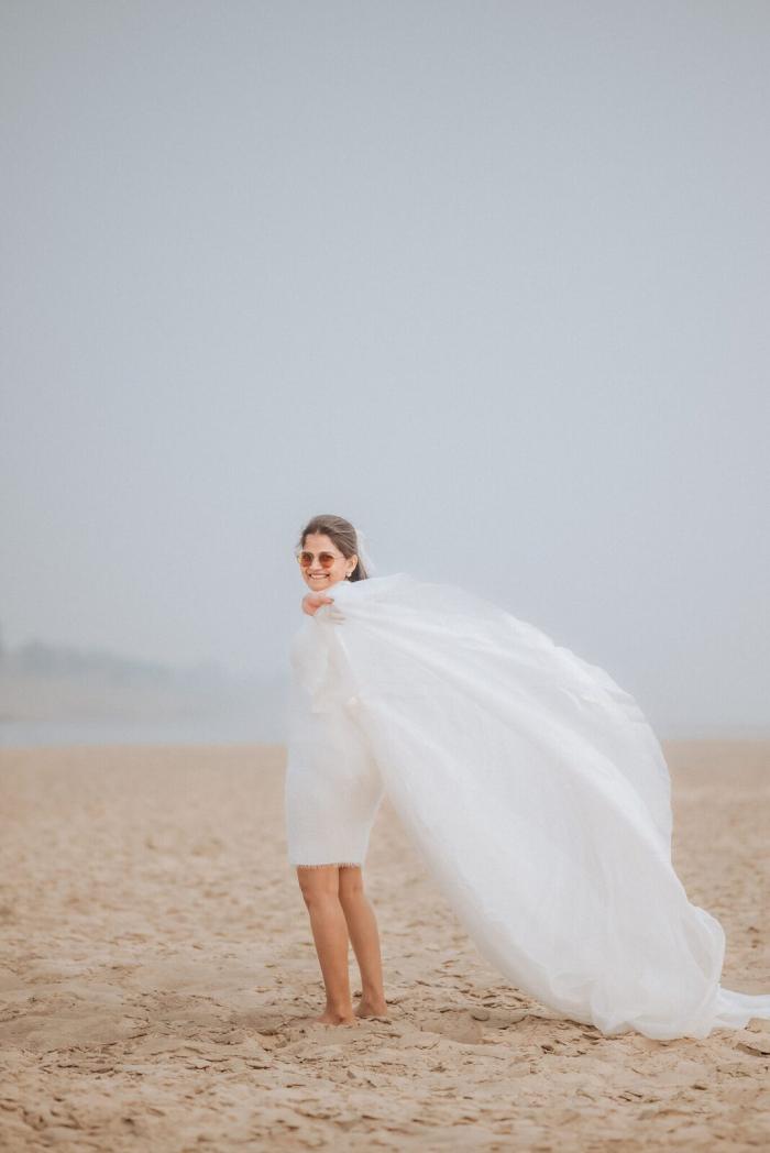 Bride-to-be with her veil catching the wind on the Yamuna sands