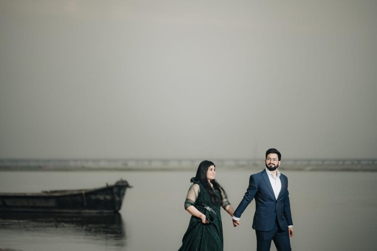 Couple by a wooden boat at the riverside during a pre-wedding shoot