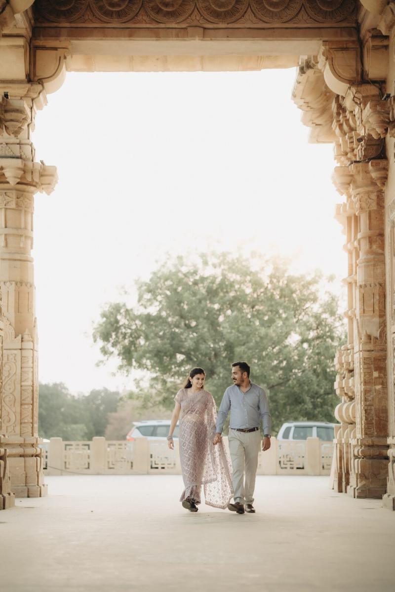Couple walking through a stone archway, pre-wedding shoot in Prayagraj