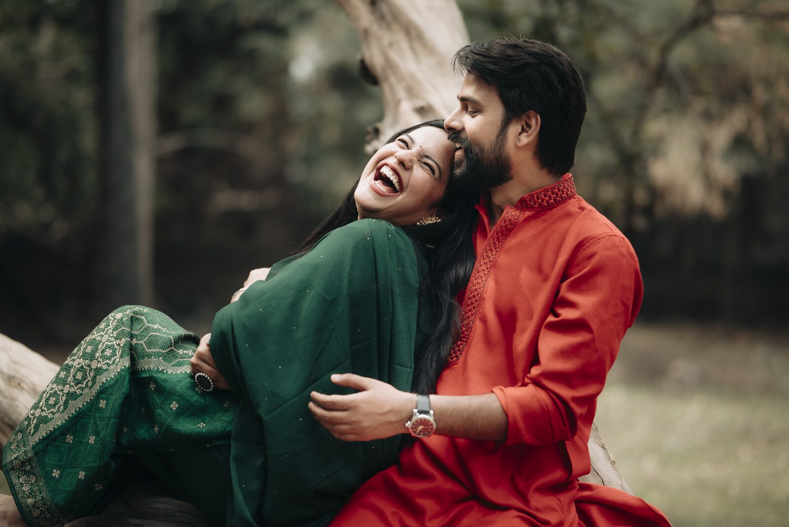 Candid pre-wedding moment of a couple laughing together outdoors