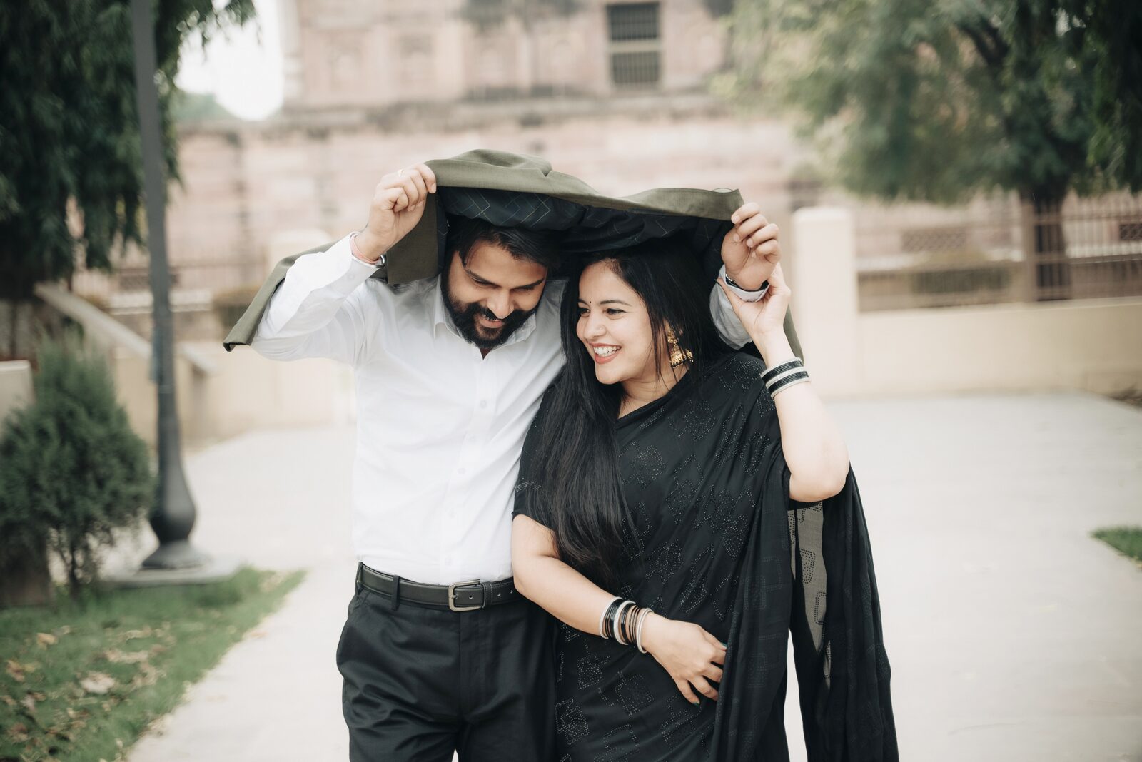 Couple sharing a dupatta over their heads during a pre-wedding shoot