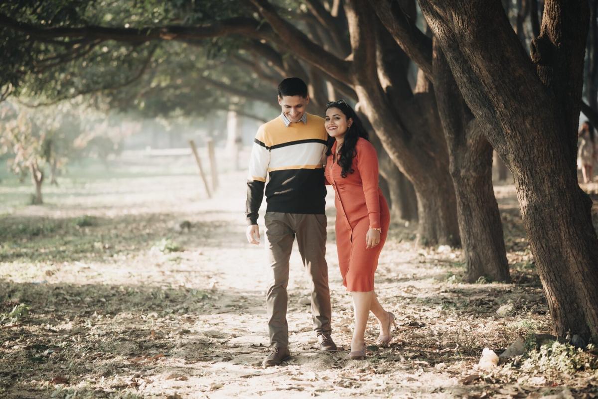 Couple walking down an avenue of trees, pre-wedding photography Prayagraj