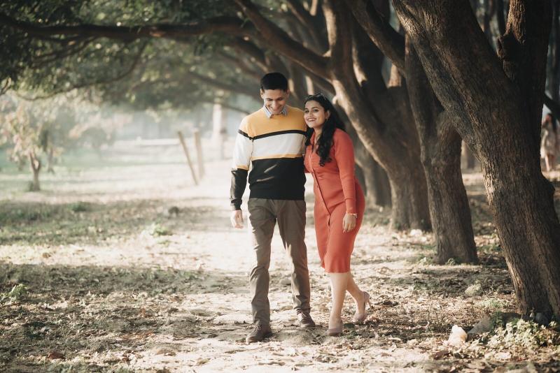 Couple walking down an avenue of trees, pre-wedding photography Prayagraj