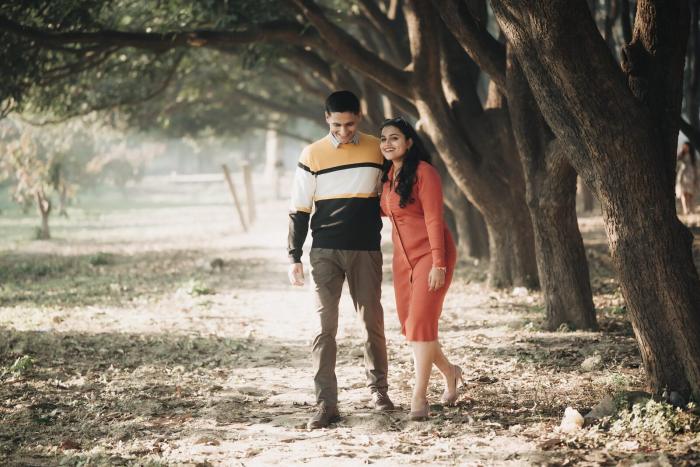 Couple walking down an avenue of trees, pre-wedding photography Prayagraj