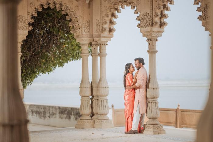 Couple in the carved sandstone arcade overlooking the river at Ram Bagiya, Prayagraj