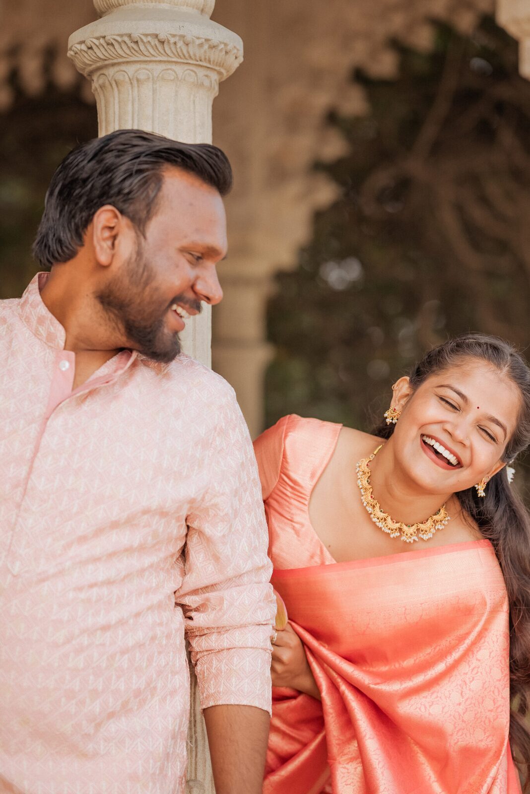 Couple laughing beside the carved columns at Ram Bagiya, Prayagraj