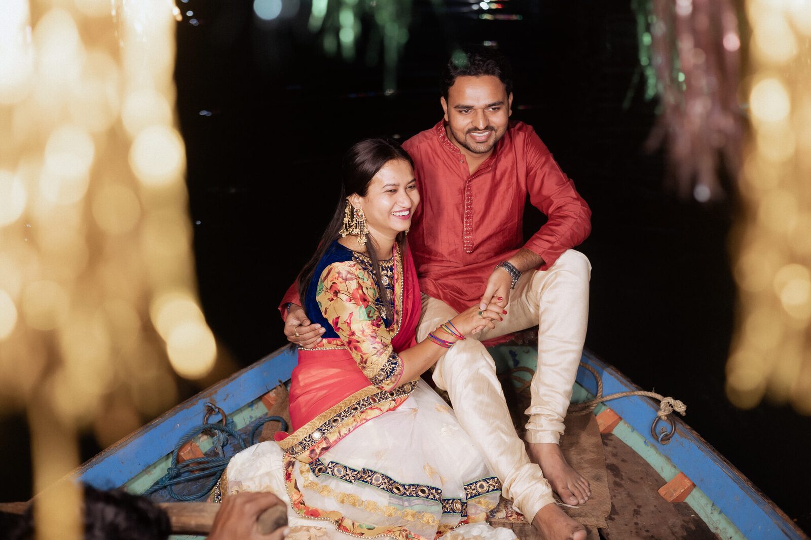 Golden bokeh around the couple on the boat at Ram Ghat, Chitrakoot