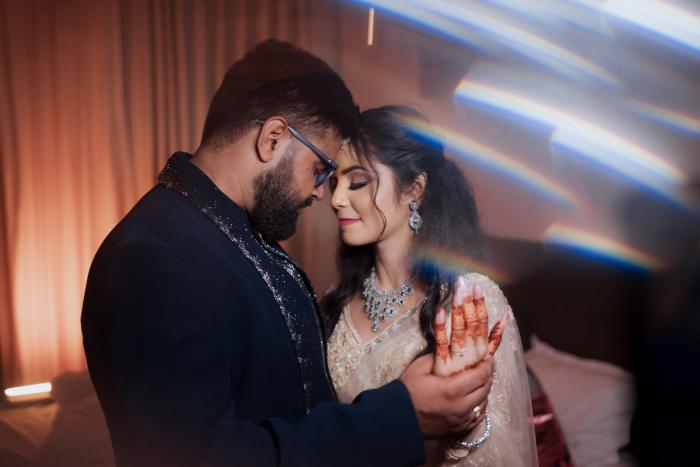 Bride and groom in a close moment under the stage lights, Allahabad