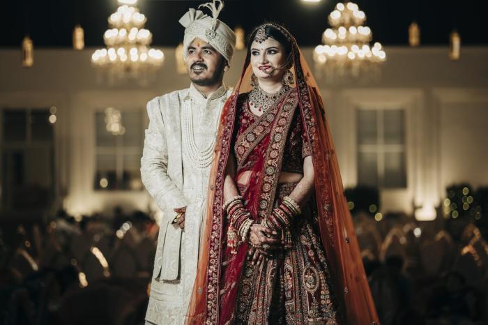 Bride and groom under chandeliers at their wedding reception in Prayagraj