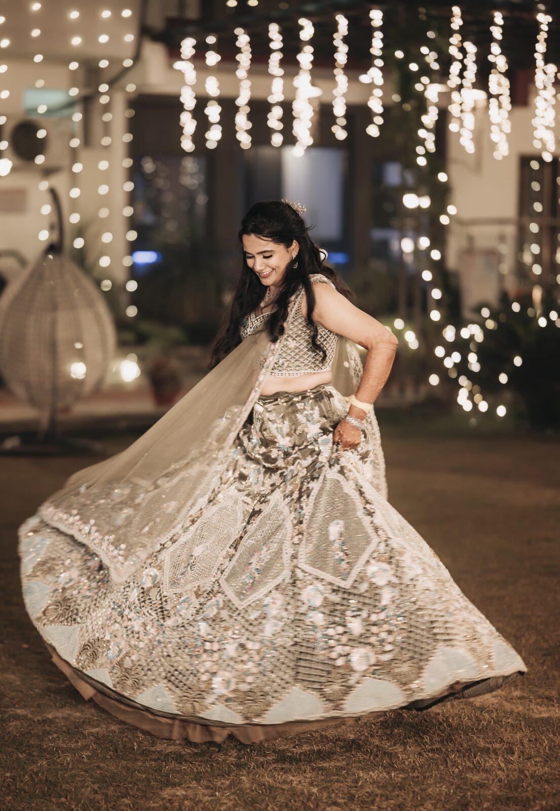 Bride twirling in a pastel lehenga under fairy lights at the sangeet