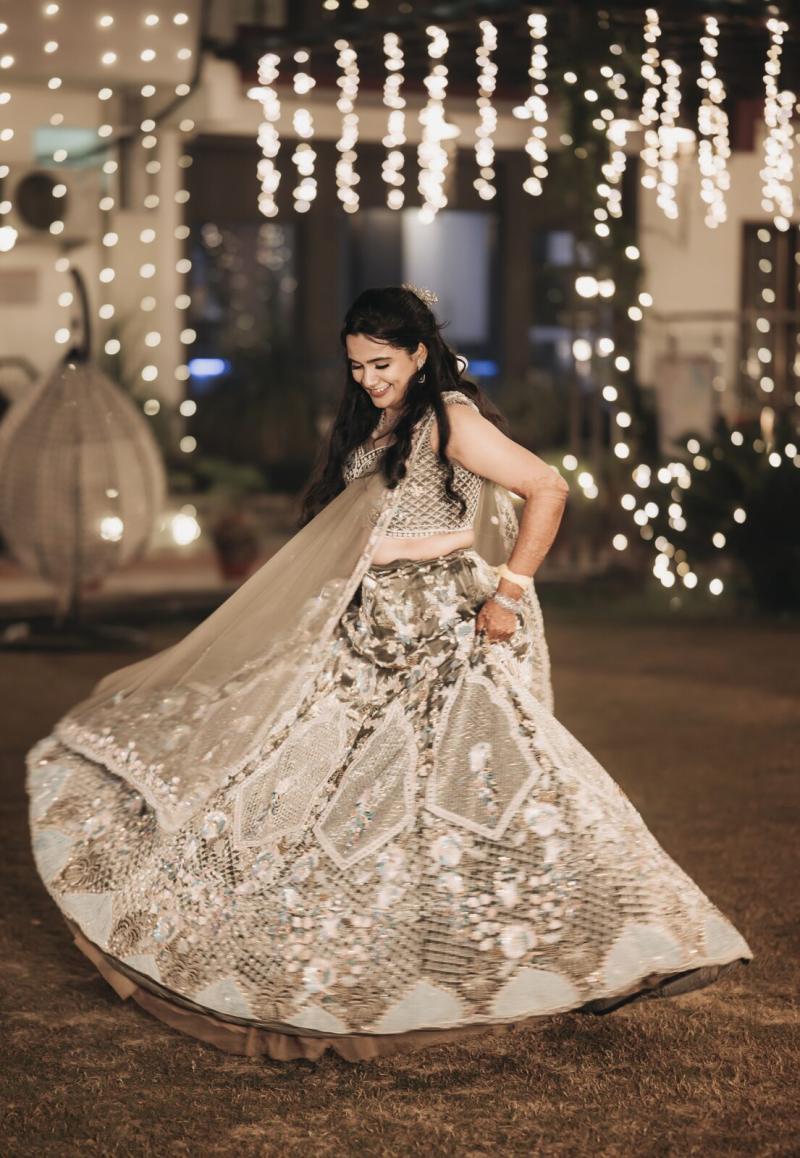 Bride twirling in a pastel lehenga under fairy lights at the sangeet